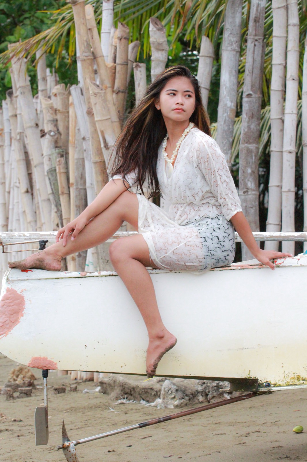 Illustrative photo of a Filipina woman seated beside bamboo