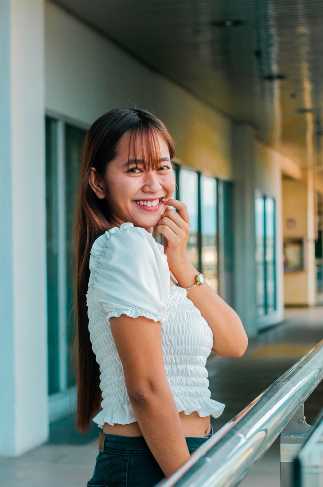 Illustrative photo of a smiling Filipina woman in a bright corridor